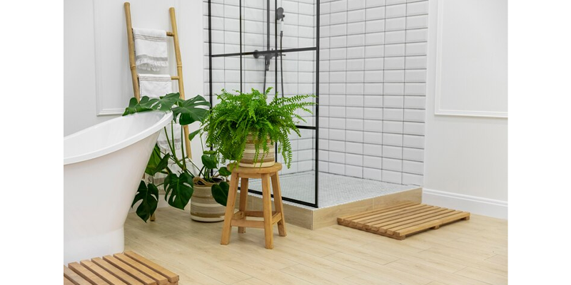 Baño con pared de cerámicos blancos, plantas de interior, bañera y ducha.