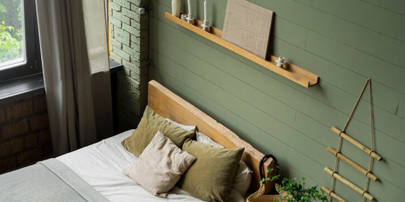 Dormitorio con cama, plantas y repisa, en tonos verdes, blanco y gris.